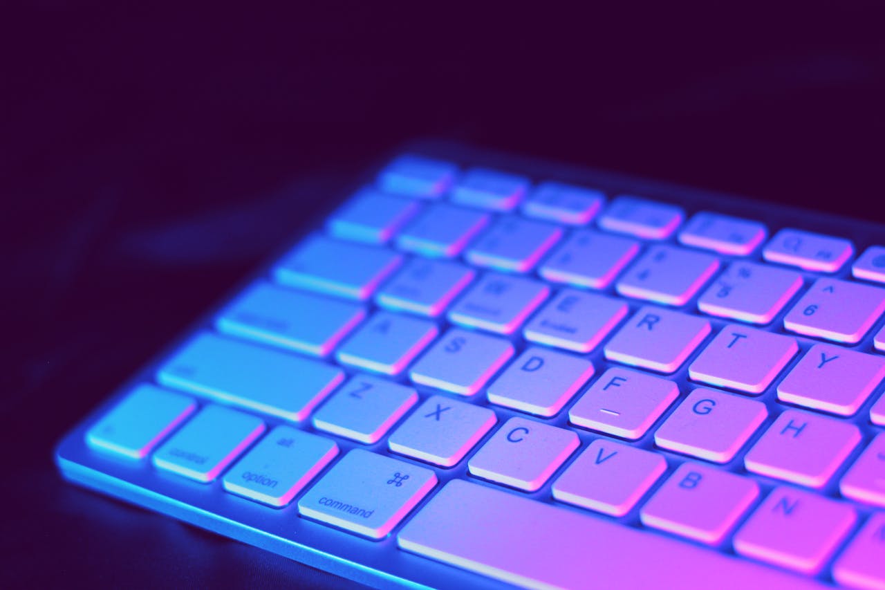 creative Close-up of a modern keyboard illuminated with vibrant purple and blue neon lighting.